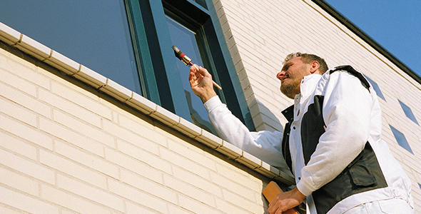 Man painting window frame